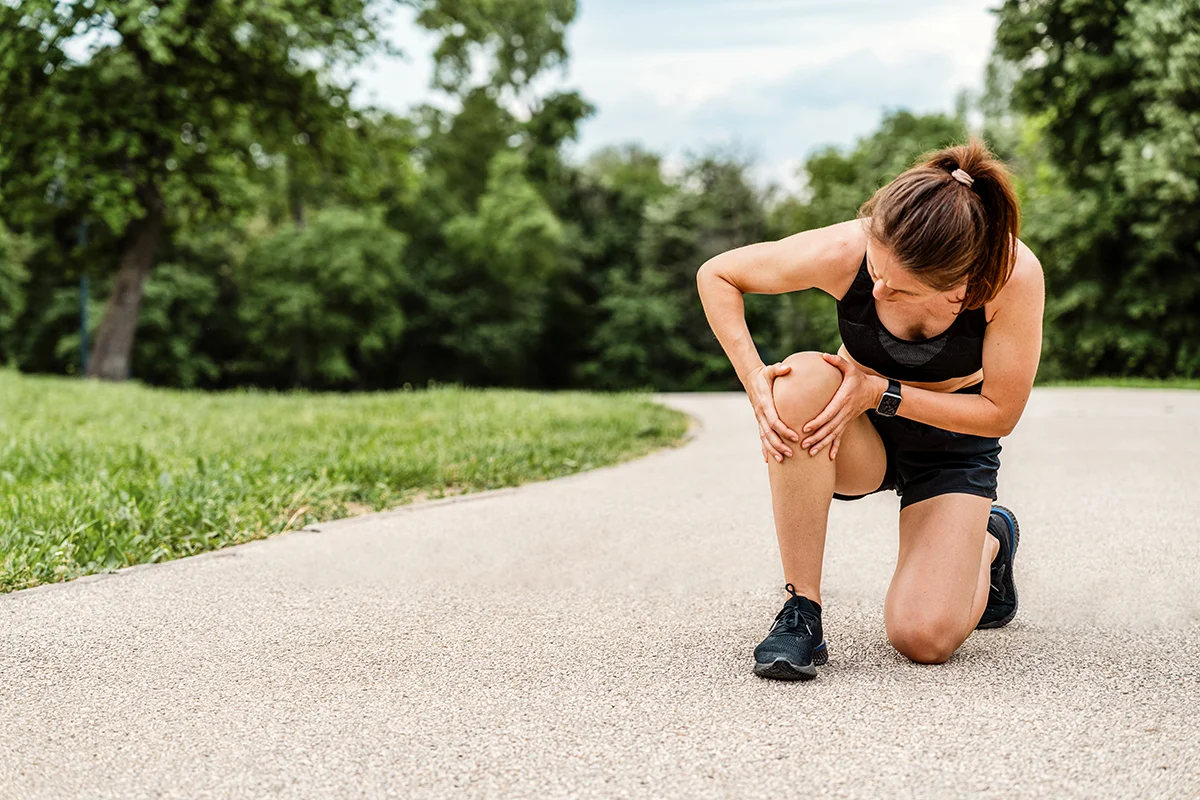 ACL Surgery in Idaho - woman athlete kneeling and holding her knee in pain